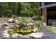 Relaxing backyard water feature with a pond, waterfall, and lush landscaping at 1107 Westridge Rd, Rougemont, NC 27572