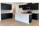 Modern kitchen with dark cabinetry, center island, and tile backsplash at 3125 Ranger Dr # 42, Durham, NC 27703