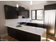 Modern kitchen with dark cabinetry, marble countertops, and stainless steel appliances at 512 Gordon St # 407, Durham, NC 27701