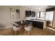Modern dining area with a dark wood table and gray chairs adjacent to a stylish kitchen at 512 Gordon St # 407, Durham, NC 27701