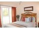 Cozy bedroom with orange curtains and a wooden bed frame at 3331 Lazy Ln, Graham, NC 27253