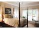 Main bedroom with a four-poster bed and large windows at 3331 Lazy Ln, Graham, NC 27253