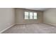 Bright bedroom with neutral carpeting and large windows at 3635 Water Mist Ln, Raleigh, NC 27604