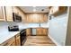 L-shaped kitchen with stainless steel appliances and wood cabinets at 1500 River Mill Drive Dr # 110, Wake Forest, NC 27587