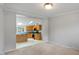Dining room with view into kitchen, carpeted floor, and neutral walls at 1510 Logan St, Durham, NC 27704