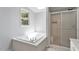 Main bathroom with a bathtub, shower, and skylight at 1510 Logan St, Durham, NC 27704