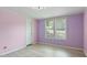 Bright bedroom with two windows, a closet, and light pink and purple walls at 1510 Logan St, Durham, NC 27704