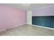 Bright bedroom with pink and purple walls, wood-look flooring, and a large closet at 1510 Logan St, Durham, NC 27704