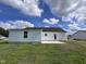 Rear view of a single-story house with white siding, a patio, and grassy yard at 161 Grace Ridge Ct, Benson, NC 27504