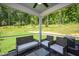 Screened porch with wicker furniture and wooded backyard view at 226 Beacon Dr, Pittsboro, NC 27312