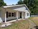 White house with a porch and a flag, surrounded by trees at 3716 Pearl Rd, Raleigh, NC 27610