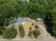 Aerial view of a house, detached garage, and large lot with mature trees at 3716 Pearl Rd, Raleigh, NC 27610