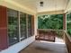Front porch with a wooden swing and views of the wooded area at 901 Tanglewood Dr, Siler City, NC 27344