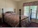 Bedroom with dark wood post bed and window seat at 901 Tanglewood Dr, Siler City, NC 27344