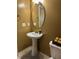 Powder room with pedestal sink and oval mirror at 506 Averasboro Dr, Clayton, NC 27520
