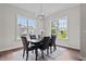 Elegant dining room with dark wood table and six chairs, featuring a chandelier and large windows at 816 Willow Tower Ct # 154, Rolesville, NC 27571