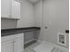 Bright laundry room with white cabinets, granite countertops, and patterned tile floor at 812 Willow Tower Ct # 155, Rolesville, NC 27571