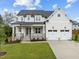 Two-story house with gray siding, stone accents, and a two-car garage at 812 Willow Tower Ct # 155, Rolesville, NC 27571