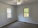 Well-lit bedroom with two windows and ceiling fan at 7622 Lindley Mill Rd, Graham, NC 27253