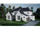 Two-story house with white brick, black roof, and wood accents at 5628 Bella Terra Ct, Wake Forest, NC 27587