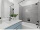 Bathroom with gray tile, a tub, and a blue vanity at 602 Rocky Knob Ct, Raleigh, NC 27601