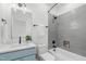 Modern bathroom with gray tile, blue vanity, and a tub at 602 Rocky Knob Ct, Raleigh, NC 27601