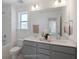 Bathroom with double vanity, gray cabinets, and a large mirror at 8820 Melvin St # 16, Willow Springs, NC 27592