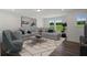 Comfortable living room with gray sectional and large windows at 8820 Melvin St # 16, Willow Springs, NC 27592