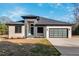 Modern ranch home with brick and stone exterior, a teal door, and glass garage door at Lot 4 Harding St, Efland, NC 27243
