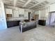 Bright kitchen with white cabinets, dark island, and recessed lighting at 6048 Scalybark Rd, Durham, NC 27712