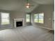 Living room with a fireplace, carpet, and large windows at 46 Scotties Ridge Dr, Princeton, NC 27569