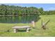 Tranquil pond scene with a bench and fishing rod at 557 Olives Chapel Rd, Apex, NC 27502