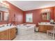 Bathroom with corner jetted tub, double vanity, and wood cabinets at 557 Olives Chapel Rd, Apex, NC 27502