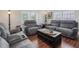 Relaxing living room with gray sofas and wood floors at 557 Olives Chapel Rd, Apex, NC 27502