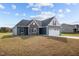 New construction home with gray siding, stone accents, and a two-car garage at 182 Oleander Ln, Sanford, NC 27332