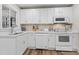 Modern kitchen with white cabinets, stainless steel appliances, and wood flooring at 1905 Wagoner St, Durham, NC 27705
