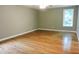 Large bedroom with hardwood floors, ceiling fan and window at 513 N Carr St, Mebane, NC 27302