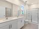 Modern bathroom with double vanity, large mirror, and glass shower at 800 Dorset Stream Dr, Fuquay Varina, NC 27526