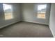 Spacious bedroom with neutral walls and carpet, featuring two windows at 90 Watermelon Dr, Franklinton, NC 27525