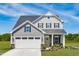 Two-story house with gray siding, landscaping, and two-car garage at 8916 Stratus St, Willow Springs, NC 27592