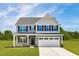 Two story house with gray siding, white trim and two-car garage at 8813 Tartan Clan Dr, Willow Springs, NC 27592