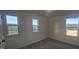 Bright bedroom with three windows and grey carpet at 53 Putnam St, Fuquay Varina, NC 27526