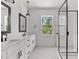 Modern bathroom with double vanity, large mirror, and walk-in shower at 6408 Tanner Oak Ln, Raleigh, NC 27613