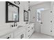 Modern bathroom with double vanity and black framed mirrors at 6408 Tanner Oak Ln, Raleigh, NC 27613