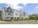 Exterior view of three-story townhouses with gray and white siding, landscaping, and parking at 716 Dorset Stream Dr, Fuquay Varina, NC 27526