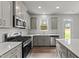 Modern kitchen features gray cabinets, stainless steel appliances, and a kitchen island at 110 Merrifield Ln, Garner, NC 27529