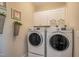 Laundry room with white washer and dryer and upper cabinets at 3138 Armeria Dr, Apex, NC 27502