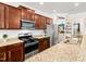 Modern kitchen with granite countertops, stainless steel appliances, and dark wood cabinets at 4301 Auburn Hills Dr, Raleigh, NC 27616