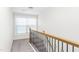 Upper hallway with carpeted stairs and wrought-iron railing at 258 Tyree Trl, Burlington, NC 27215