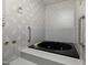 Bathroom with black whirlpool tub and gray tile surround at 2517 Oakes Plantation Dr, Raleigh, NC 27610